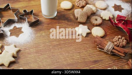 Montrant assortis biscuits des fêtes et emporte-pièces sur le dessus de table de la cuisine avec du lait, du sucre, de la cannelle Banque D'Images