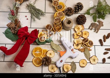 Plat de Noël rustique avec tranches d'orange séchées, pommes de pin et décorations naturelles Banque D'Images