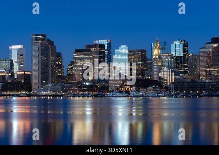 Une belle vue du lever du soleil sur les gratte-ciel du centre-ville de Boston, vue de l'est de Boston à travers le port, avec la tour Custom House. Banque D'Images