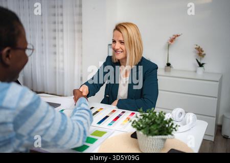 Diverses femmes d'affaires se serrant la main concluant un accord au bureau Banque D'Images