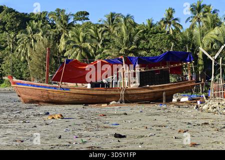 Bateau en bois sur la plage entourée de palmiers et ciel clair, plage, village de pêcheurs, plage de Ngapali, Thandwe, Birmanie, Birmanie, Myanmar Banque D'Images