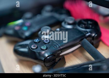 Grappe de contrôleurs de jeu modernes avec icônes de boutons colorés, surfaces ergonomiques de prise en main et bords partiels de l'appareil créant une scène technologique dynamique Banque D'Images