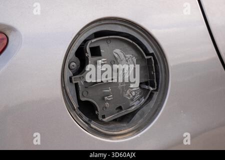 Compartiment de couvercle de carburant en plastique cassé sur un véhicule gris Banque D'Images