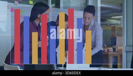 Collaboration de trois collègues dans des chemises d'affaires examinant l'ordinateur portable dans le bureau, avec superposition de graphique à barres Banque D'Images