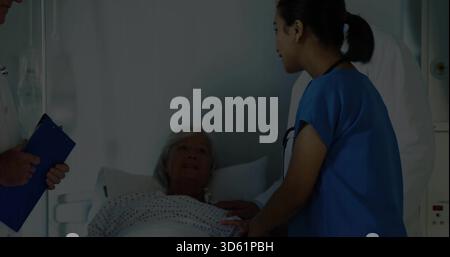 Patient senior incliné recevant le contact de l'infirmière dans des gommages bleus au chevet, portant une blouse à pois. Hôpital, personnes âgées, médecin, soignant, stéthoscope, Banque D'Images