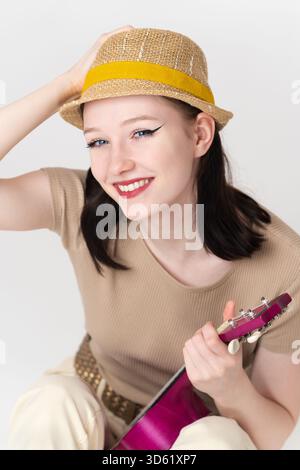 Portrait de musicienne heureuse avec ukulélé est souriant et regardant la caméra avec une expression amicale. Femme ukulélé artiste Caucasien ethnicité Banque D'Images
