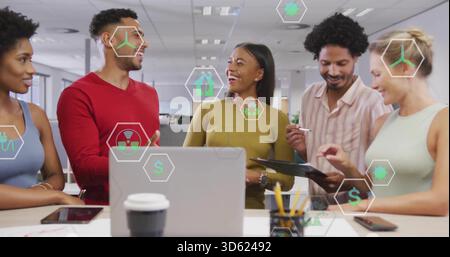 Discuter de cinq coéquipiers dans une ambiance décontractée intelligente, faire des gestes autour d'un ordinateur portable au bureau avec des icônes vertes Banque D'Images