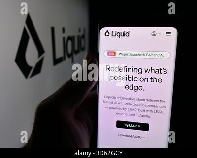 Dans cette illustration photo, une personne tient un smartphone avec la page Web de la société américaine d'intelligence artificielle Liquid ai sur l'écran devant le logo. (Photo timon Schneider / SOPA images/SIPA USA) *** strictement à des fins éditoriales *** Banque D'Images