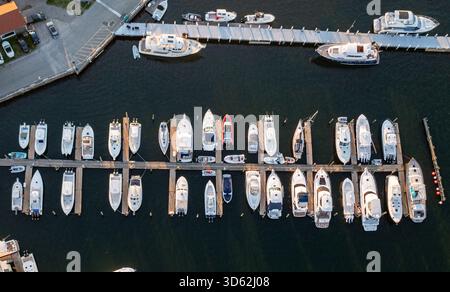 Vue aérienne de bateaux élégants nichés dans la marina, reflétant la lueur dorée du soleil sur l'eau, Newport, Rhode Island, États-Unis. Banque D'Images