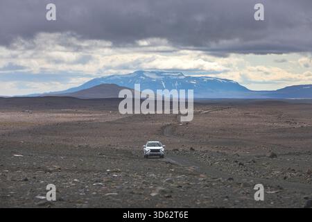 Voiture solitaire sur la route montagneuse de Kjoelur, avec le mont Blafell, Blafellshnjukur, en arrière-plan, Islande Banque D'Images