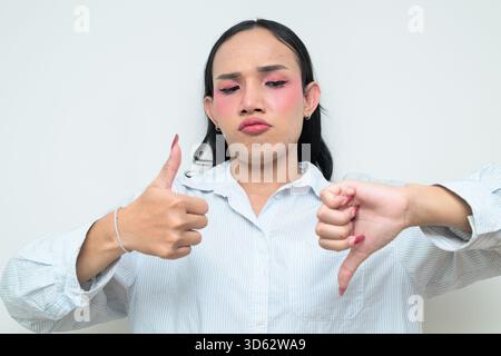Portrait studio d'un jeune transgenre thaïlandais avec maquillage et cheveux longs. Concept d'expression de genre, fierté LGBTQ et inclusivité montrant un Banque D'Images