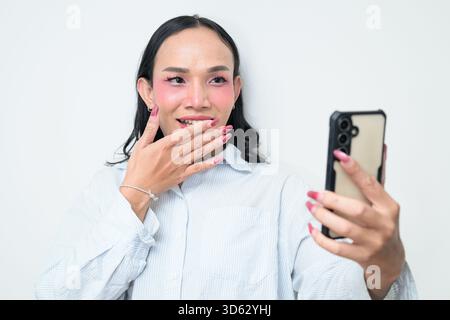 Portrait studio d'un jeune transgenre thaïlandais avec maquillage et cheveux longs. Concept d'expression de genre, fierté LGBTQ et inclusivité montrant un Banque D'Images