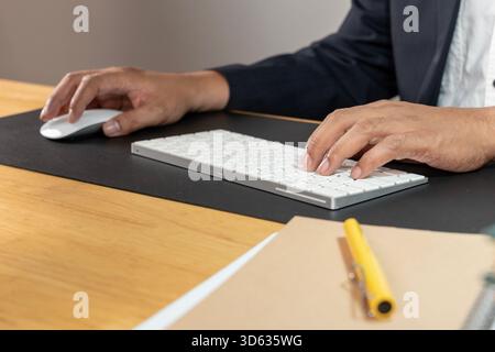 Le jeune employé de bureau est assis à l'ordinateur en travaillant avec son esprit à l'esprit Banque D'Images