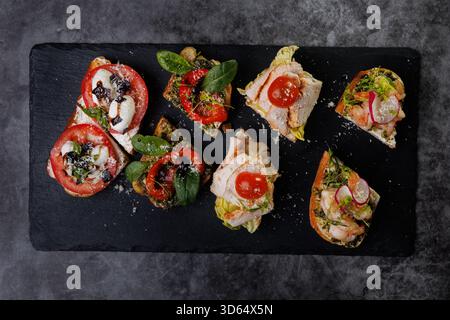 Plat élégant de crostini en bouchées garni de tomates, fromage, basilic et fruits de mer. Idéal pour les fêtes, la restauration ou les divertissements élégants avec vibra Banque D'Images