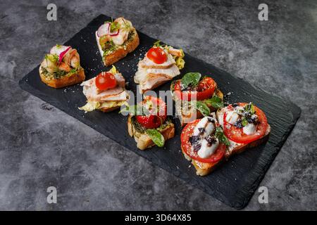 Plat élégant de crostini en bouchées garni de tomates, fromage, basilic et fruits de mer. Idéal pour les fêtes, la restauration ou les divertissements élégants avec vibra Banque D'Images