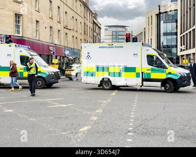 Ambulances d'urgence et policiers bloquant une rue de la ville lors d'un accident à Édimbourg avec plusieurs piétons à proximité Banque D'Images