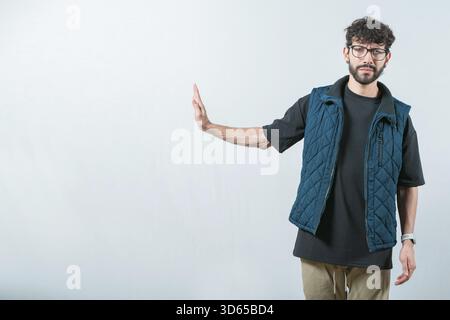 Serious Guy faisant un geste de rejet avec la paume de la main isolée. Mécontent jeune homme ignorant avec la main de la paume Banque D'Images