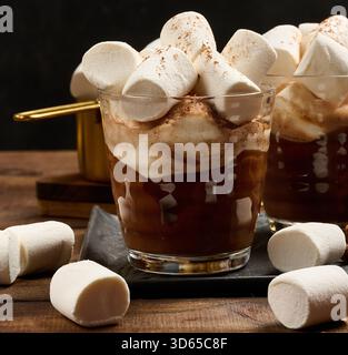 Deux verres de chocolat chaud avec des guimauves moelleuses sur une planche d'ardoise. Gros plan de la boisson d'hiver. Banque D'Images
