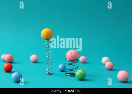 Les sphères sur des ressorts de différentes tailles prennent une distance ou un avantage sur le reste du groupe Banque D'Images