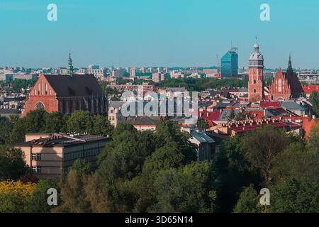 Vue aérienne panoramique de la vieille ville de Kraków avec ses églises en briques historiques et la ligne d'horizon moderne au-delà. Banque D'Images