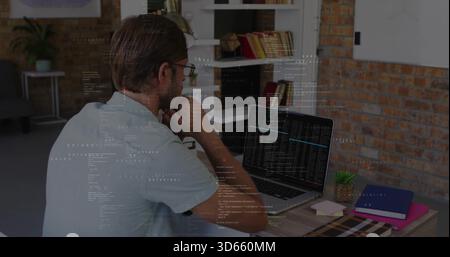 Étudier l'homme mi-adulte analysant le code sur ordinateur portable au bureau à domicile, avec étagères succulentes cahiers Banque D'Images