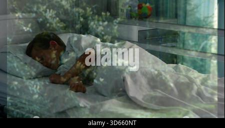 Enfant endormi portant une chemise blanche couchée sur le lit avec couette blanche, boule colorée, recouvrement de feuillage Banque D'Images