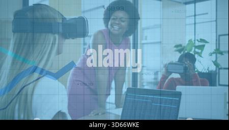 Femmes collaborant avec des casques VR, une en robe rose guidant à la table de travail, ordinateurs portables montrant des données Banque D'Images