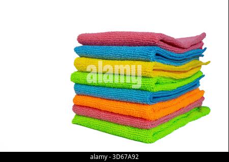 Pile soigneusement pliée de serviettes colorées sur un fond blanc. Concept de textile ménager propre adapté aux thèmes de lessive, d'hygiène et de soins à domicile. Banque D'Images