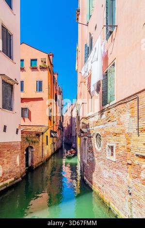 Vue sur un bras latéral du Grand canal, avec des bateaux et des façades colorées de maison, Venise, Italie Banque D'Images