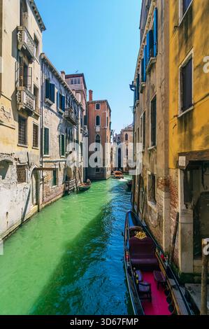 Vue sur un bras latéral du Grand canal, avec des bateaux et des façades colorées de maison, Venise, Italie Banque D'Images