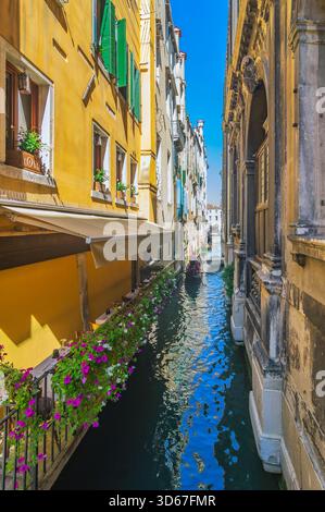 Vue sur un bras latéral du Grand canal, avec des bateaux et des façades colorées de maison, Venise, Italie Banque D'Images