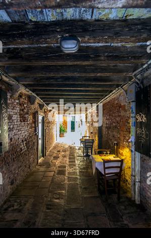 Restaurant avec places assises en plein air dans un passage souterrain, Venise, Italie Banque D'Images