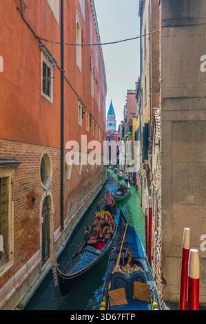 Vue sur un bras latéral du Grand canal, avec des bateaux et des façades colorées de maison, Venise, Italie Banque D'Images