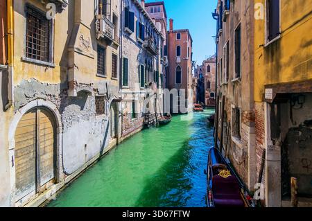 Vue sur un bras latéral du Grand canal, avec des bateaux et des façades colorées de maison, Venise, Italie Banque D'Images