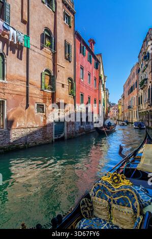 Vue sur un bras latéral du Grand canal, avec des bateaux et des façades colorées de maison, Venise, Italie Banque D'Images