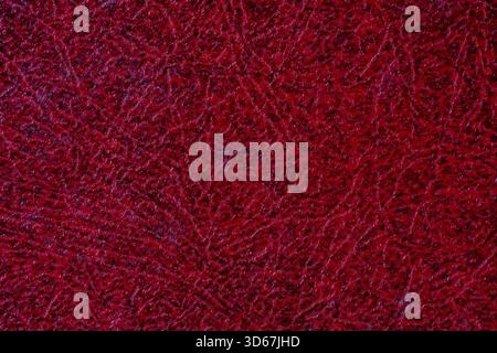 Texture de fond texturée abstraite rouge foncé au point avec des taches lumineuses, gros plan Banque D'Images