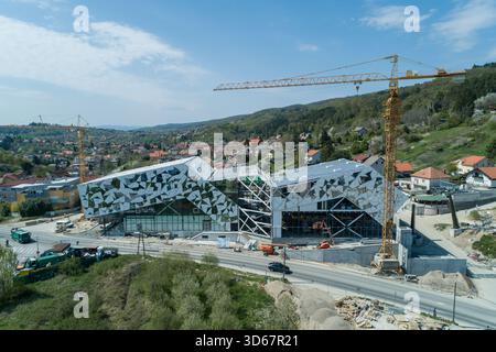 Vue aérienne d'un bâtiment moderne en construction avec des grues dressées sur fond d'une colline verdoyante, Zagreb, Croatie. Banque D'Images