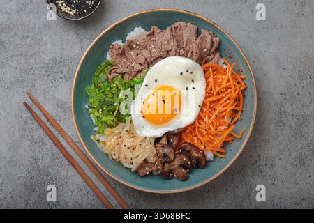 Bibimbap - riz coréen avec du bœuf, des légumes et des œufs frits Banque D'Images