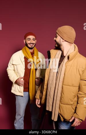 Deux frères jumeaux vêtus de tenues tendance, souriants et profitant de leur temps ensemble. Banque D'Images