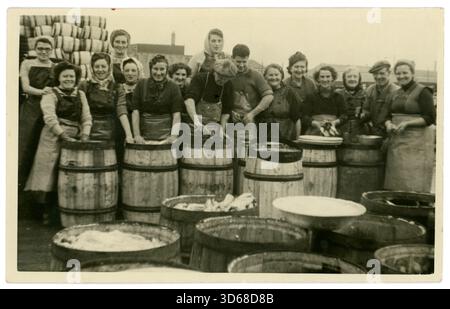Photographie vintage originale de pishwives, avec du poisson salé dans des fûts, tonneliers clou sur des couvercles, industrie de pêche traditionnelle Écosse Royaume-Uni datée 1947. Banque D'Images
