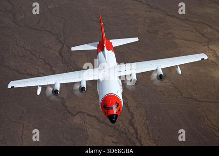 Lockheed C-130A Hercules (N117TG) exploité par International Air Response lors d'une mission de photographie air-air au-dessus de l'Arizona. Ce Hercules de premier modèle, série 182-3018, est capturé en vol au-dessus du paysage désertique, mettant en valeur le profil distinctif et la conception traditionnelle du transport à turbopropulseurs à quatre moteurs classique Banque D'Images