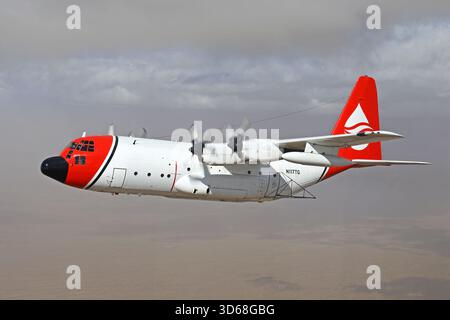 Lockheed C-130A Hercules (N117TG) exploité par International Air Response lors d'une mission de photographie air-air au-dessus de l'Arizona. Ce Hercules de premier modèle, série 182-3018, est capturé en vol au-dessus du paysage désertique, mettant en valeur le profil distinctif et la conception traditionnelle du transport à turbopropulseurs à quatre moteurs classique Banque D'Images