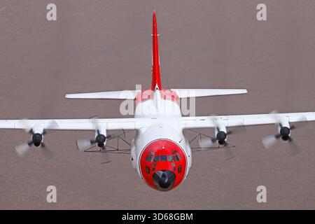 Lockheed C-130A Hercules (N117TG) exploité par International Air Response lors d'une mission de photographie air-air au-dessus de l'Arizona. Ce Hercules de premier modèle, série 182-3018, est capturé en vol au-dessus du paysage désertique, mettant en valeur le profil distinctif et la conception traditionnelle du transport à turbopropulseurs à quatre moteurs classique Banque D'Images