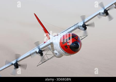 Lockheed C-130A Hercules (N117TG) exploité par International Air Response lors d'une mission de photographie air-air au-dessus de l'Arizona. Ce Hercules de premier modèle, série 182-3018, est capturé en vol au-dessus du paysage désertique, mettant en valeur le profil distinctif et la conception traditionnelle du transport à turbopropulseurs à quatre moteurs classique Banque D'Images