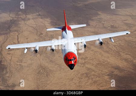 Lockheed C-130A Hercules (N117TG) exploité par International Air Response lors d'une mission de photographie air-air au-dessus de l'Arizona. Ce Hercules de premier modèle, série 182-3018, est capturé en vol au-dessus du paysage désertique, mettant en valeur le profil distinctif et la conception traditionnelle du transport à turbopropulseurs à quatre moteurs classique Banque D'Images