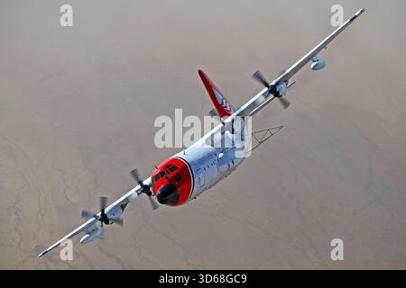 Lockheed C-130A Hercules (N117TG) exploité par International Air Response lors d'une mission de photographie air-air au-dessus de l'Arizona. Ce Hercules de premier modèle, série 182-3018, est capturé en vol au-dessus du paysage désertique, mettant en valeur le profil distinctif et la conception traditionnelle du transport à turbopropulseurs à quatre moteurs classique Banque D'Images