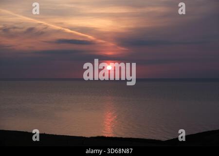 Coucher de soleil sur une mer irlandaise tranquille depuis Trefor North Wales Banque D'Images