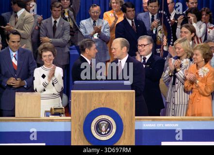 KANSAS CITY, MISSOURI, États-Unis - 19 août 1976 - le président américain Gerald Ford, en tant que candidat républicain, serre la main à Ronald Reagan, adversaire de l'investiture, lors de la soirée de clôture de la Convention nationale républicaine 1976 au Kemper Arena de Kansas City, Missouri, États-Unis. Le candidat à la vice-présidence Bob Dole est à l'extrême gauche, puis Nancy Reagan, le gouverneur Ronald Reagan est au centre serrant la main du président Gerald Ford, le vice-président Nelson Rockefeller est juste à droite de Ford, suivi de Susan Ford et de la première dame Betty Ford - photo : Geopix/Maison Blanche/William Fitz-Patrick Banque D'Images