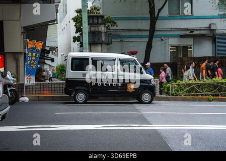 Fourgon de police de Tokyo garé pendant que les piétons attendent le long de la rue centrale Banque D'Images