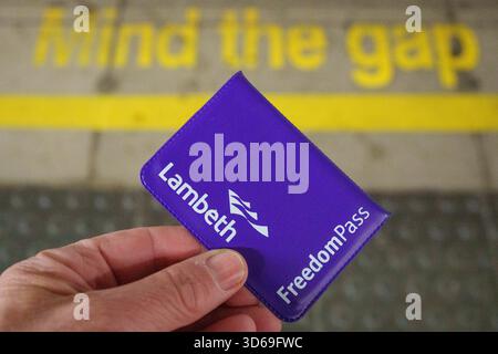 Gros plan détaillé d'une main tenant un Freedom Pass délivré par le Conseil de Lambeth à la gare de Farringdon, le 19 novembre 2025, à Londres, en Angleterre. Les Freedom Pass permettent aux plus de 66 ans de voyager gratuitement en dehors des heures de pointe à travers Londres, ainsi que de voyager en bus en dehors des heures de pointe dans le reste de l'Angleterre. Le régime financé par les conseils londoniens a cependant été critiqué pour ses dépenses de fonctionnement qui, en 2024/5, s'élevaient à 291 millions de livres sterling Banque D'Images